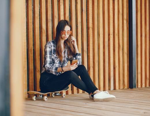 Beautiful girl with skate. Girl in glasses. Woman with phone.